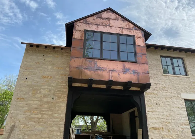 Copper metal panel facade on a stone building for Skylight Installation in Pecan Grove