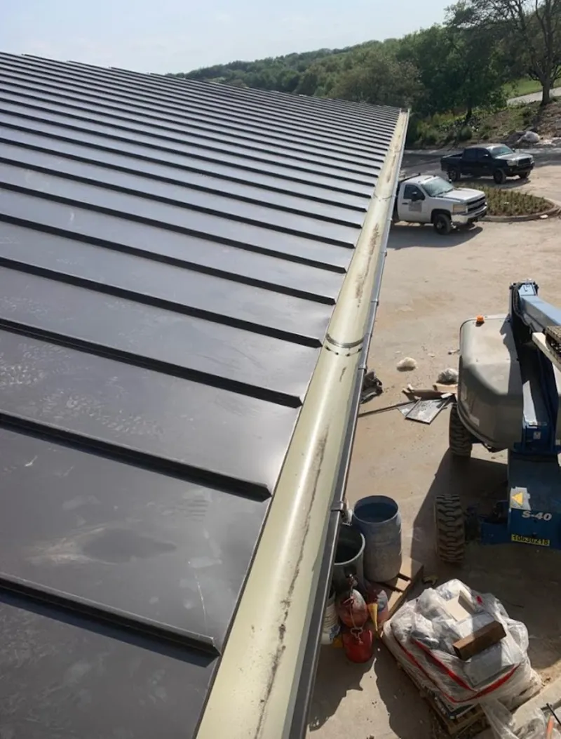 Standing seam panel and gutter detail on a metal roofing jobsite in Pecan Grove